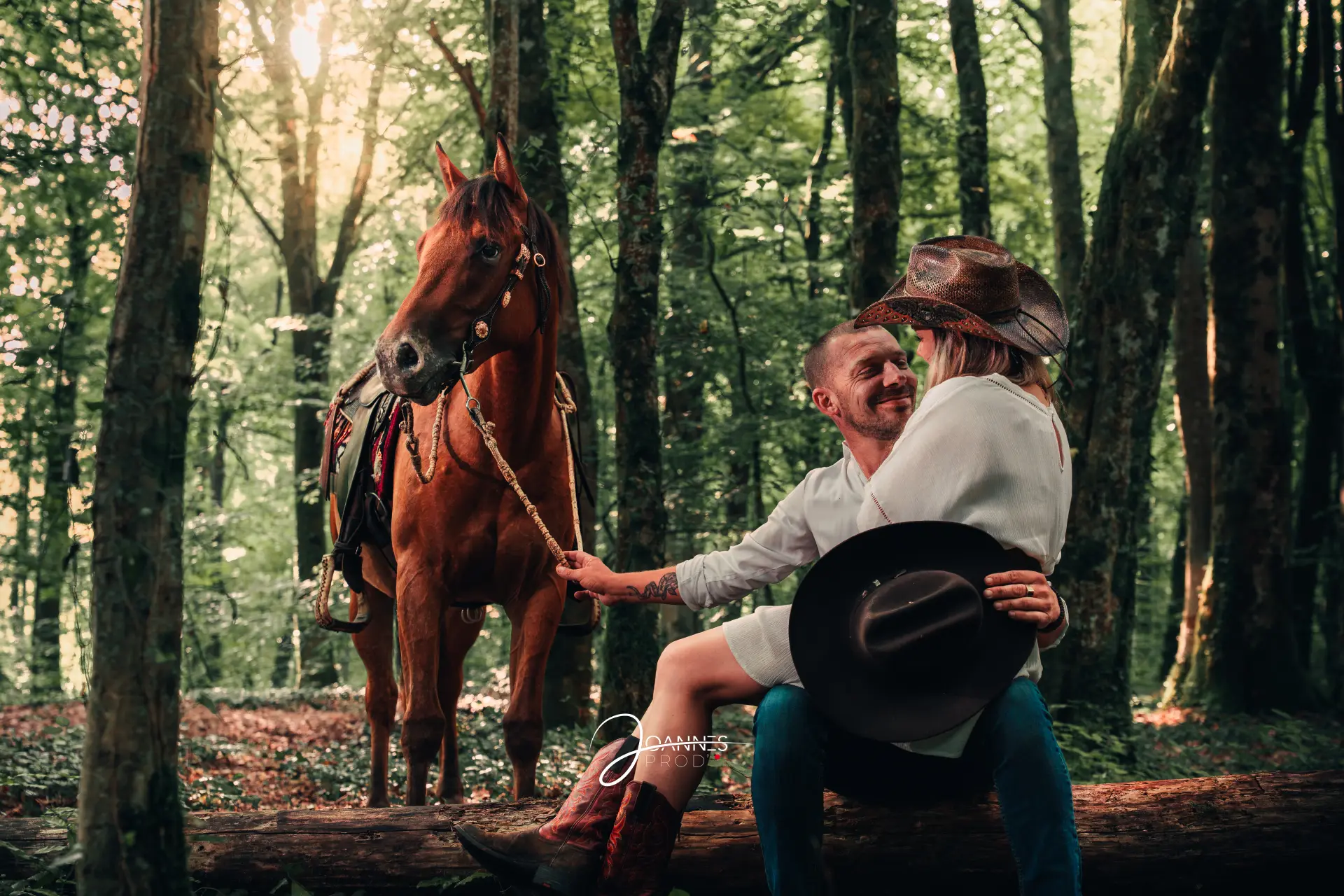 Couple assis sur un tronc d'arbre & cheval